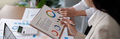 People reviewing printed charts and a calculator